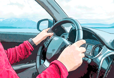 Das Bild zeigt eine Person, die ein Auto fährt. Die Perspektive ist aus dem Inneren des Autos aufgenommen und zeigt die Hände der Person am Lenkrad. Die Person trägt eine rote Jacke und eine Uhr am linken Handgelenk.